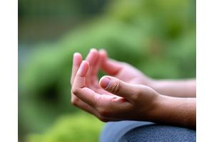 Особа медитира у мирном окружењу, фокус на унутрашњи мир.