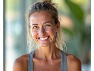 Milica, nasmejana odrasla žena u sportskoj odeći, koja pokazuje poboljšanu fizičku spremnost.